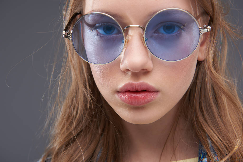 Viehättävä teini tyttö yllään sininen pyöreä lasit
 - Valokuva, kuva