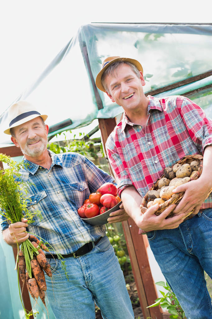 Bauern tragen verschiedene Gemüsesorten auf dem Hof - Foto, Bild