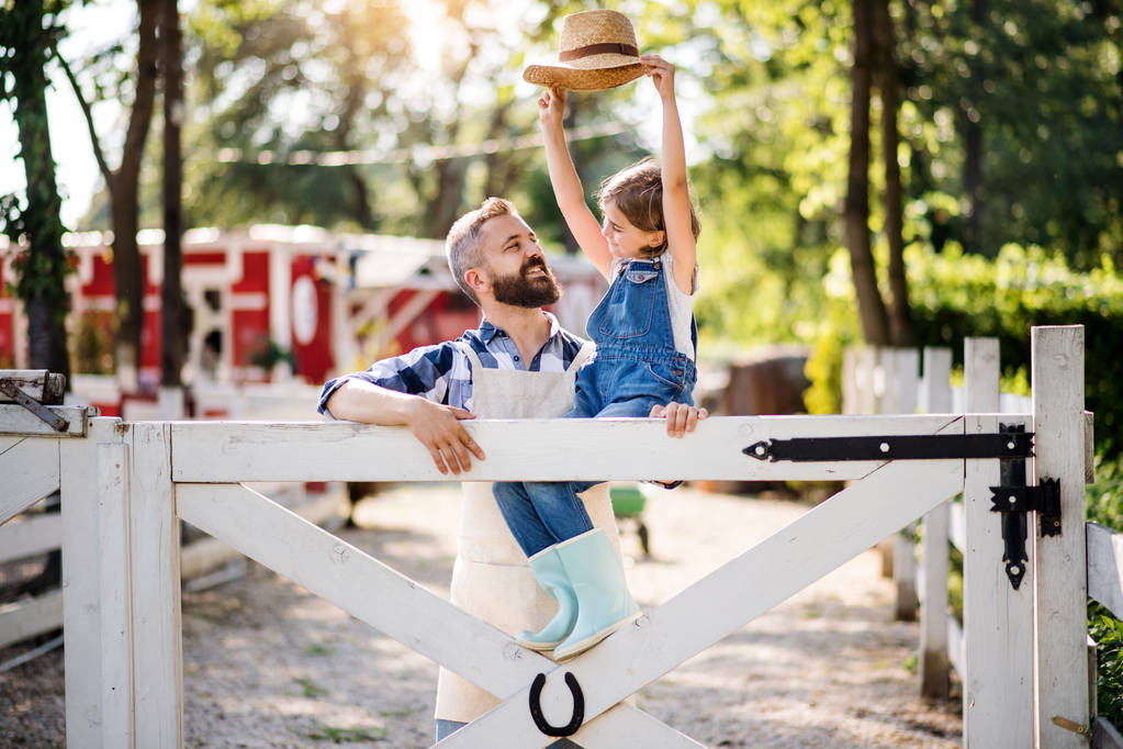 Un retrato del padre con una hija pequeña al aire libre en la granja familiar
. - Foto, Imagen