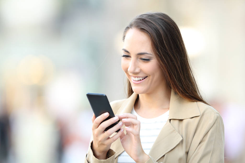 Boldog alkalmi hölgy használ mobiltelefonján az utcán - Fotó, kép