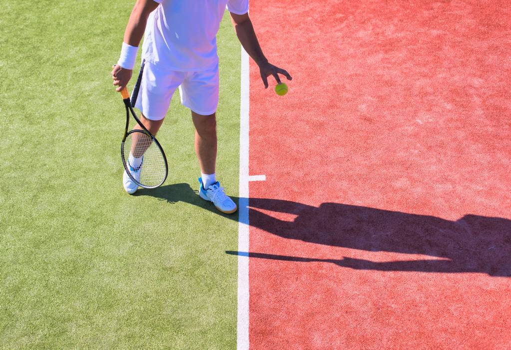 Sebevědomý dospělý muž hraje tenis za slunečného dne - Fotografie, Obrázek
