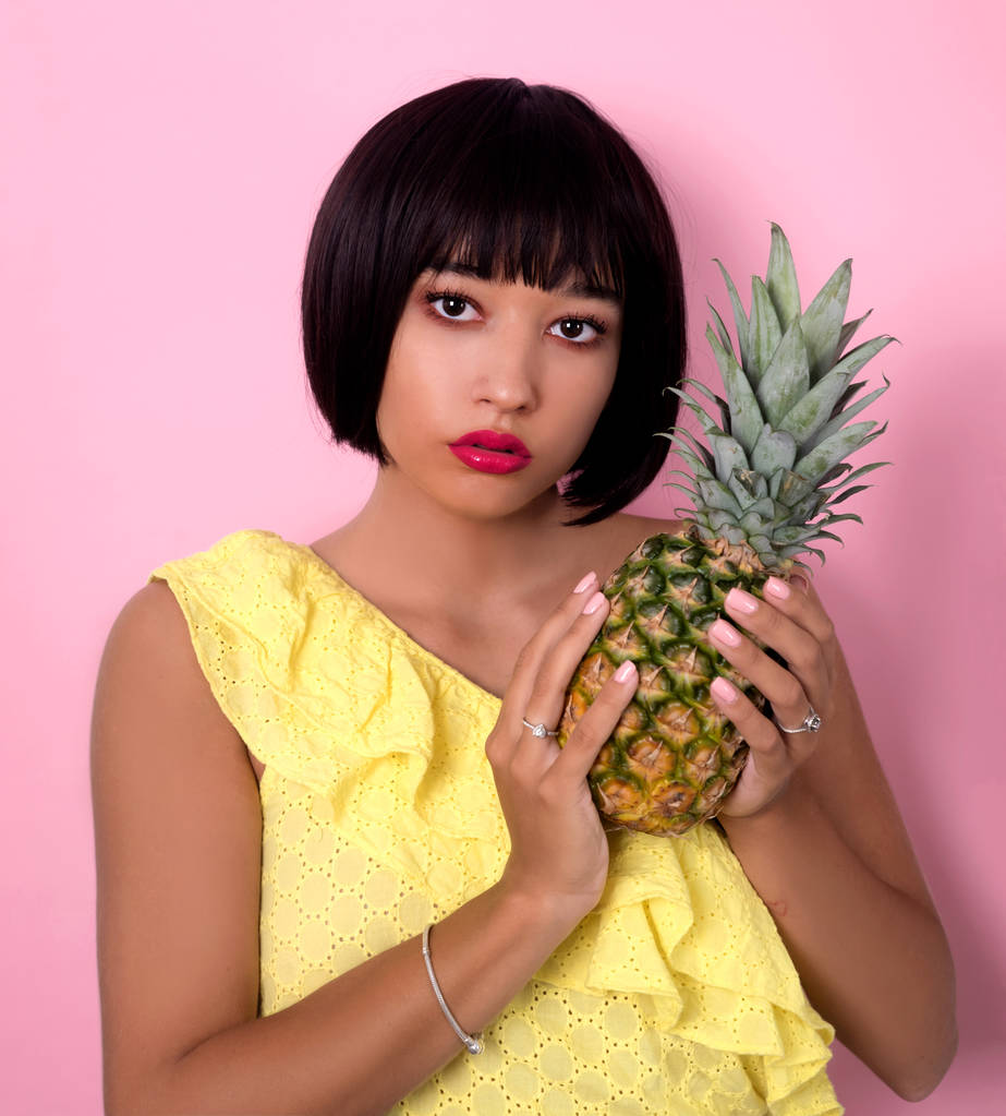 jonge vrouw poseren met ananas  - Foto, afbeelding