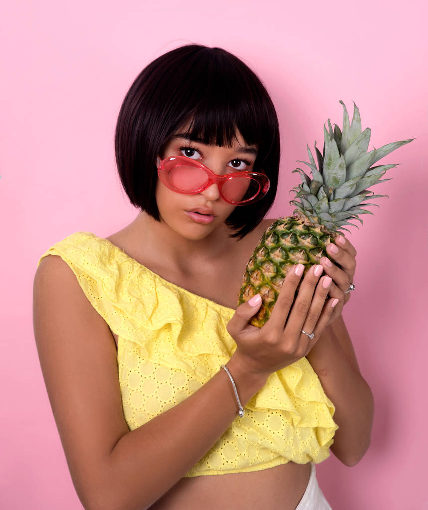 Giovane donna in posa con ananas
  - Foto, immagini