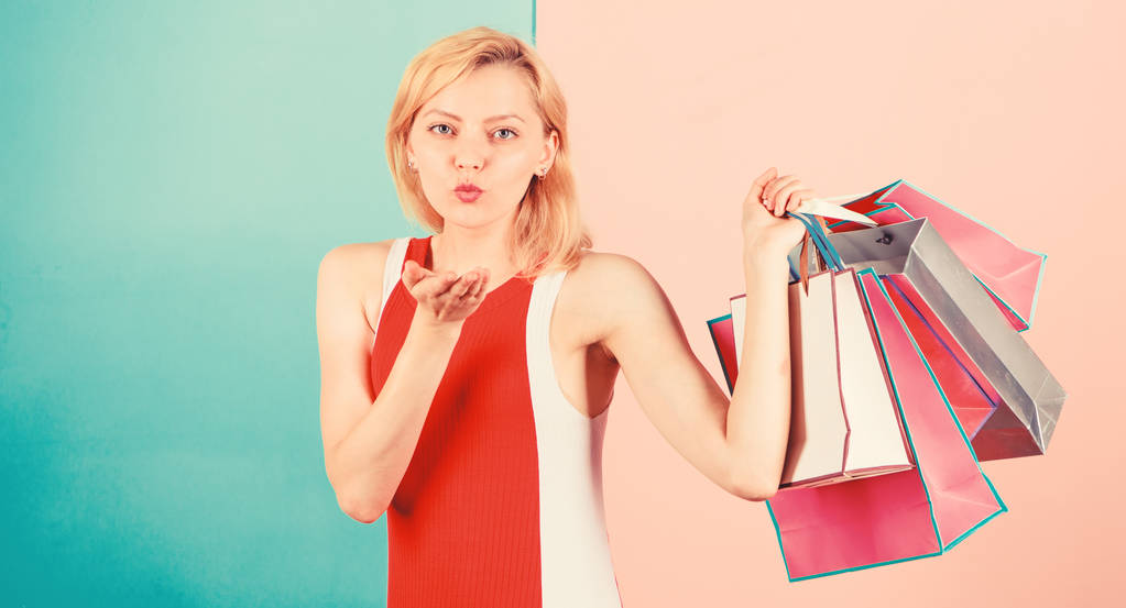 Συμβουλές για να ψωνίσετε πωλήσεις με επιτυχία. Κορίτσι απολαμβάνουν ψώνια ή απλά πήρε δώρα γενεθλίων. Γυναίκα κόκκινο φόρεμα κρατήσει δέσμη τσάντες ψώνια μπλε ροζ φόντο. Αγόρασε ό, τι θέλεις. Κορίτσι ικανοποιημένη με τα ψώνια - Φωτογραφία, εικόνα