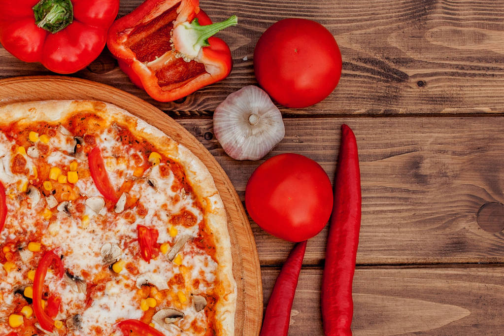 Pizza a červené víno na dřevěném podkladu stolu. Horní pohled s mezerou pro kopírování - Fotografie, Obrázek