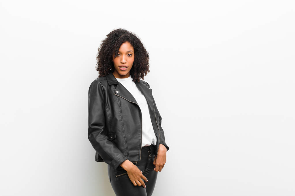 young pretty black woman wearing a leather jacket against white wall - Photo, Image