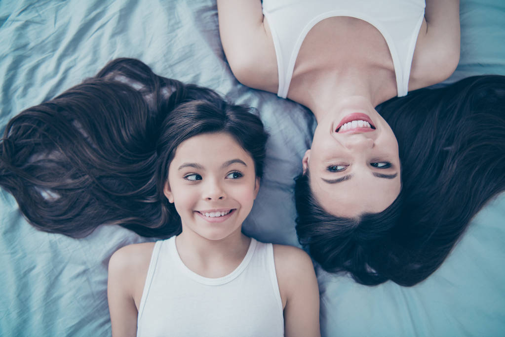 Close-up top above high angle view portrait of two nice beautiful attractive lovely tender feminine shine adorable cheerful cheery people spending holiday weekend lying on blue linen - Photo, Image