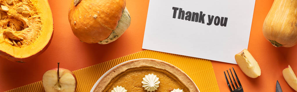 vista superior de pastel de calabaza con tarjeta de agradecimiento sobre fondo naranja con manzanas, plano panorámico
 - Foto, imagen