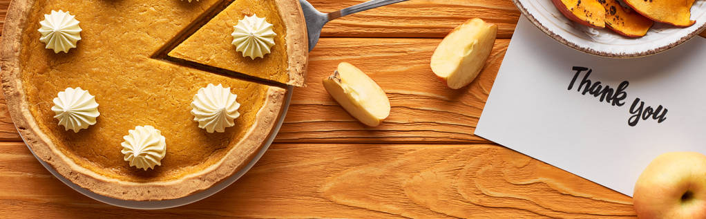top view of pumpkin pie with thank you card on wooden table with apples, panoramic shot - Photo, Image