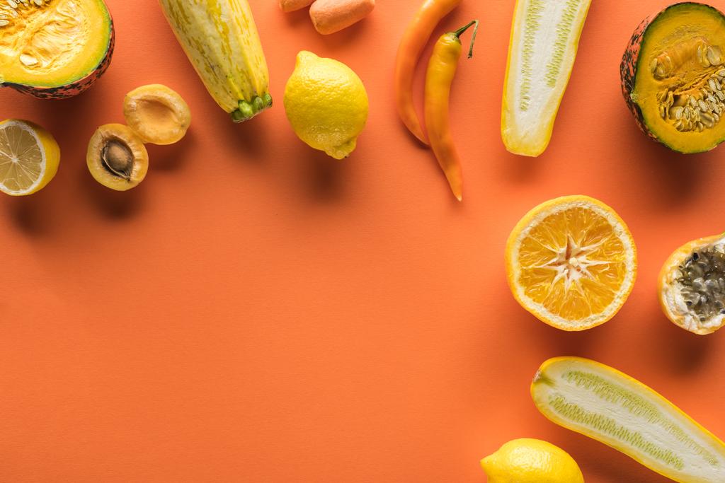 vista superior de frutas e legumes amarelos no fundo laranja com espaço de cópia
 - Foto, Imagem