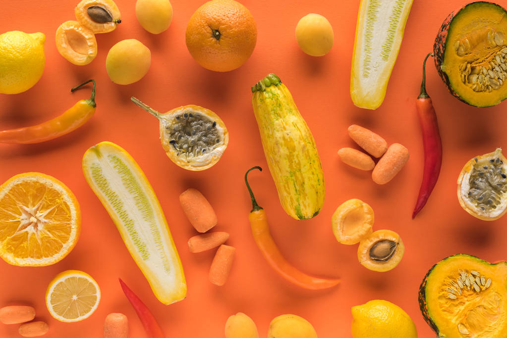 вид сверху на желтые фрукты и овощи на оранжевом фоне
 - Фото, изображение