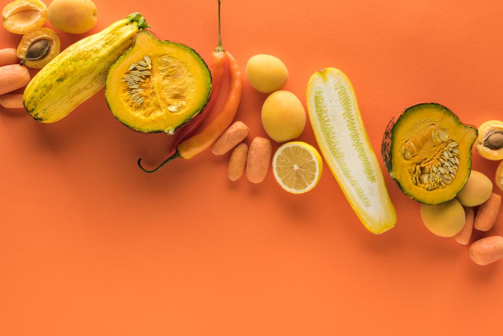 felső nézet a sárga gyümölcsök és zöldségek narancssárga háttér másolási hely - Fotó, kép
