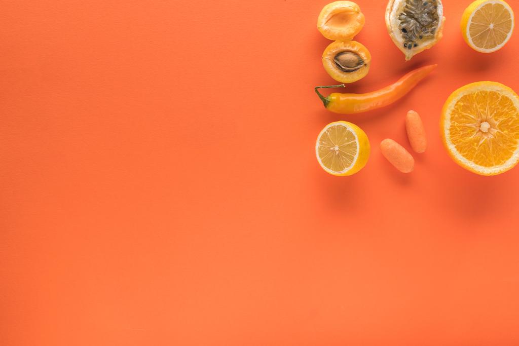 コピースペースのあるオレンジの背景の黄色い果物や野菜の上からの眺め - 写真・画像