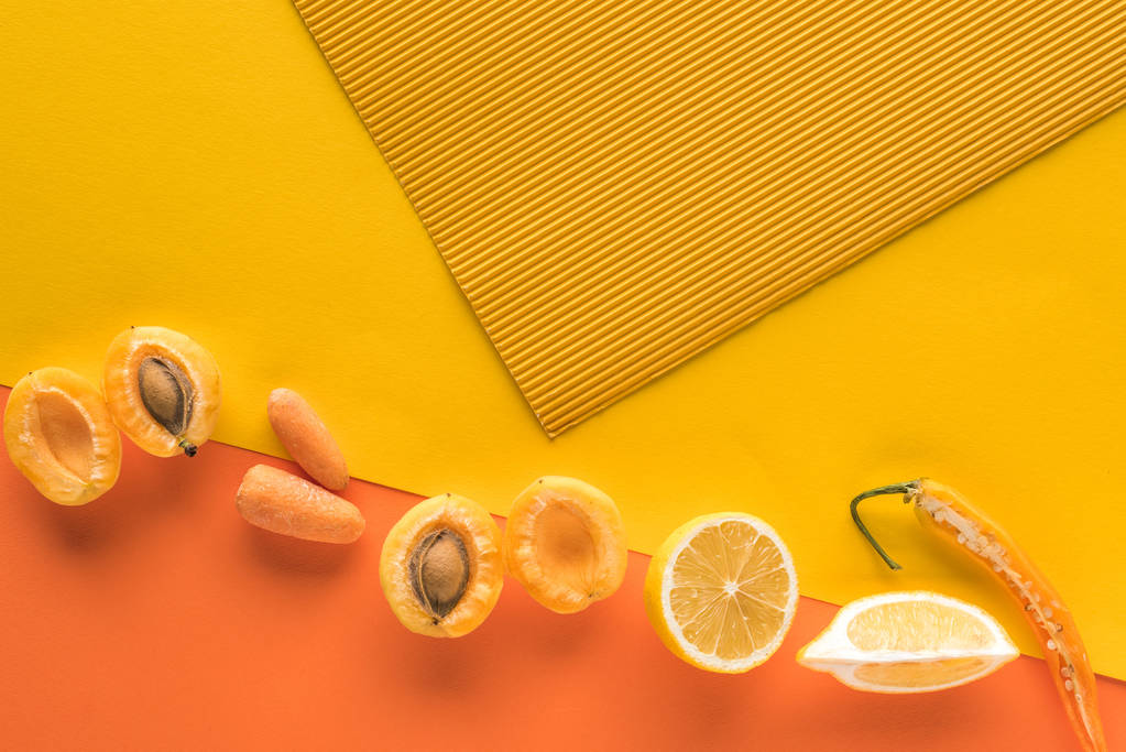 bovenaanzicht van verse groenten en fruit op gele en oranje achtergrond met kopieerruimte - Foto, afbeelding
