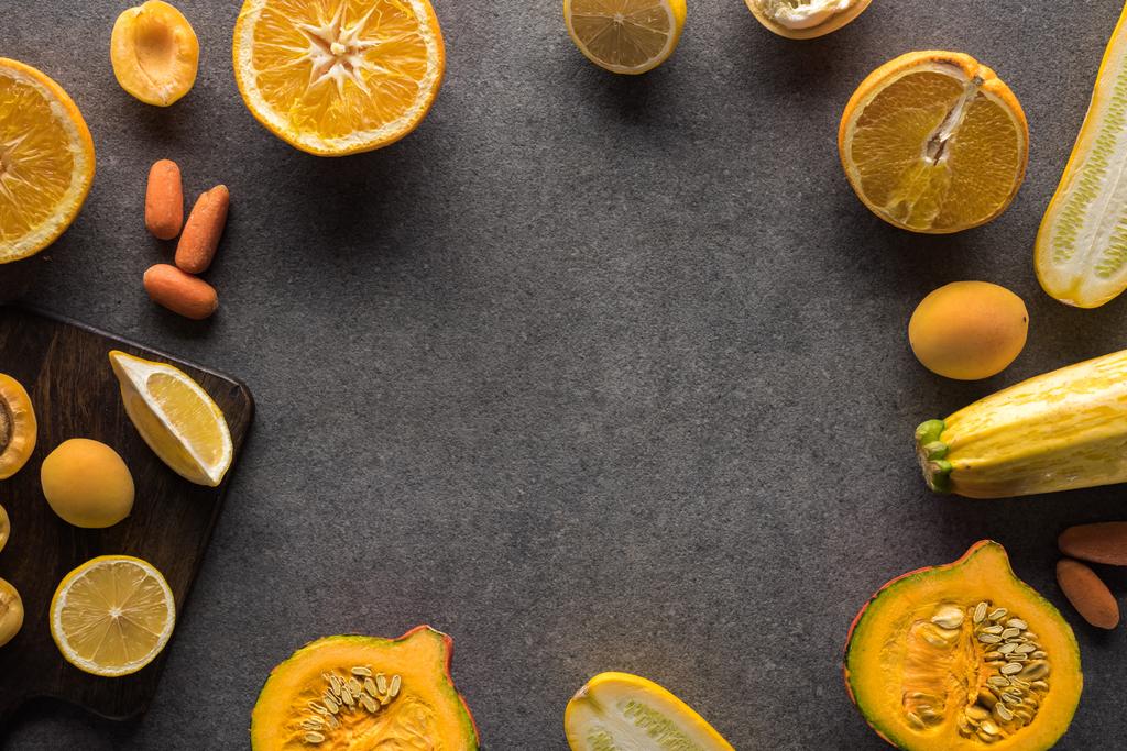marco de frutas y verduras amarillas sobre fondo texturizado gris con espacio de copia
 - Foto, imagen