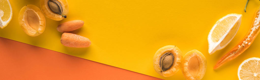 vista superior de frutas e legumes amarelos no fundo laranja com espaço de cópia, tiro panorâmico
 - Foto, Imagem