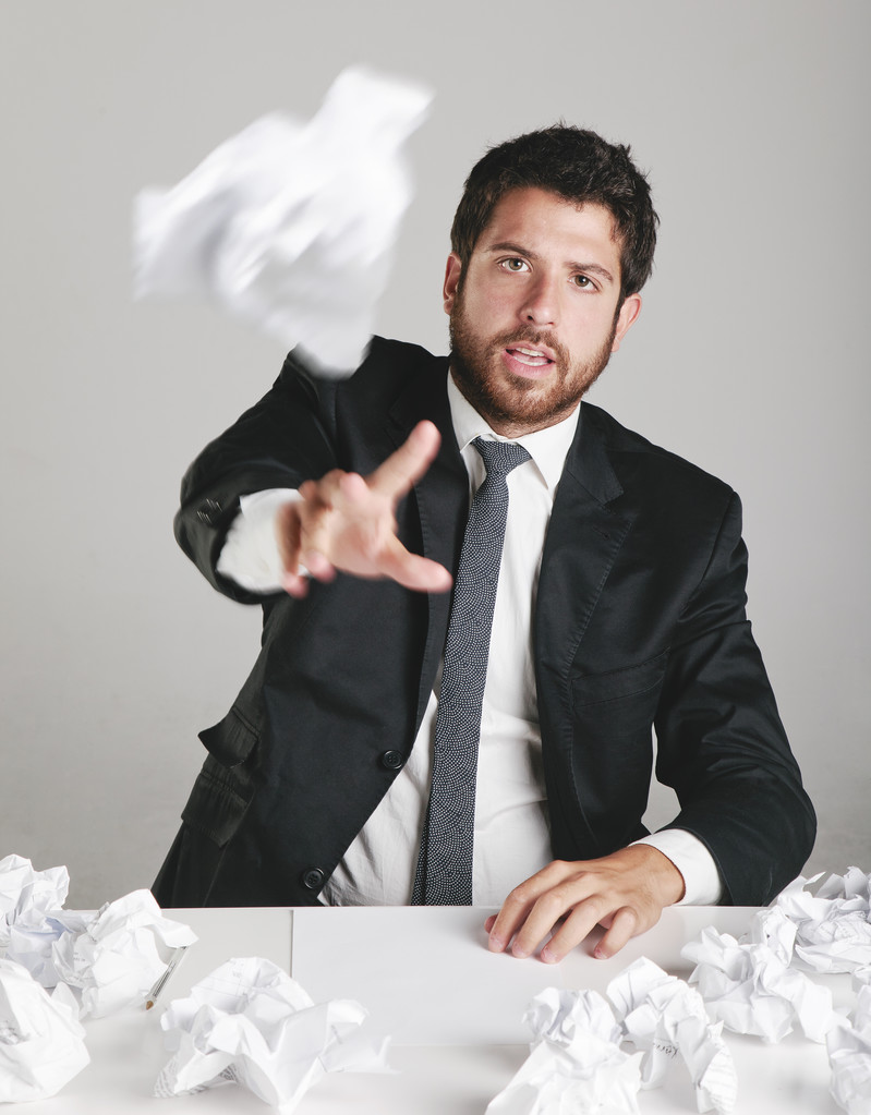 Portrait of a young businessman tired and throwing a paper. - Photo, Image