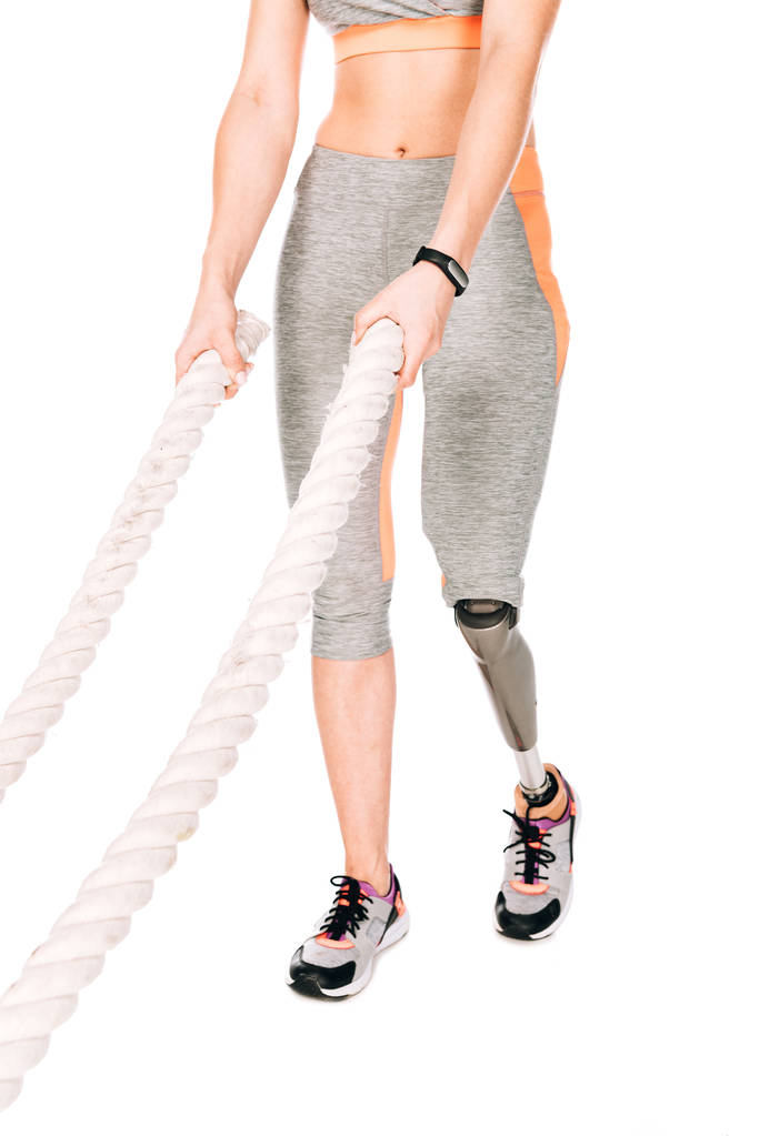 обрезанный вид спортсменки-инвалида с протезной тренировкой ног с веревками, изолированными на белом
 - Фото, изображение