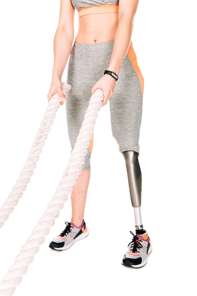 Ausgeschnittene Ansicht einer behinderten Sportlerin mit Beinprothesen-Training mit Seilen isoliert auf weiß - Foto, Bild