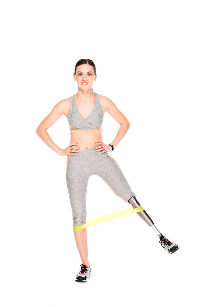 vue pleine longueur de sportive handicapée souriante avec entraînement par prothèse avec bande de résistance isolée sur blanc
 - Photo, image