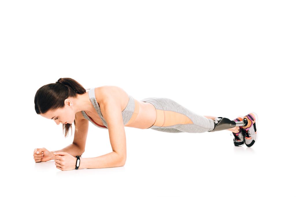 Behinderte Sportlerin mit Prothese steht isoliert auf weißer Planke - Foto, Bild