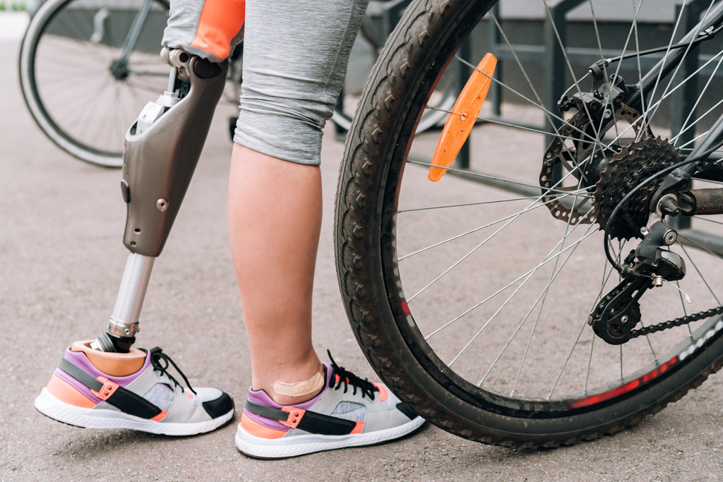 Teilansicht behinderter Sportlerin mit Fahrrad auf Straße - Foto, Bild