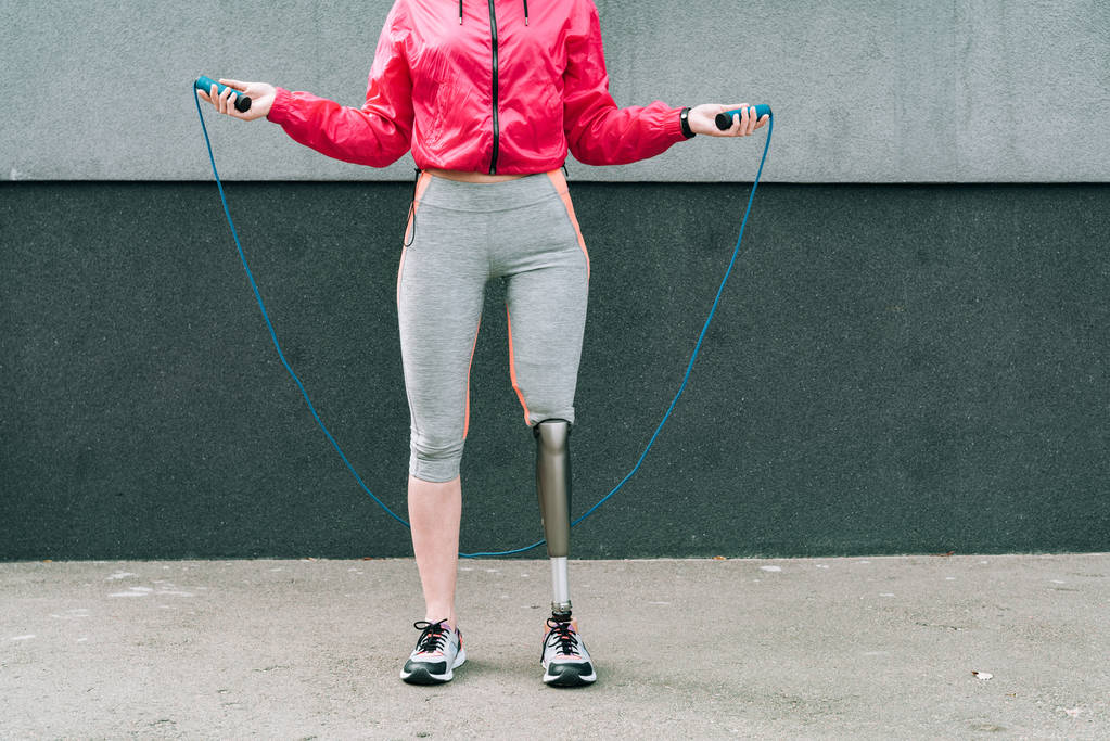 visão parcial de desportista com deficiência pulando corda na rua
 - Foto, Imagem