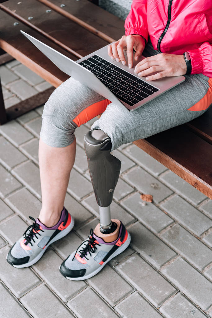 partial view of disabled sportswoman typing on laptop on street - Photo, Image