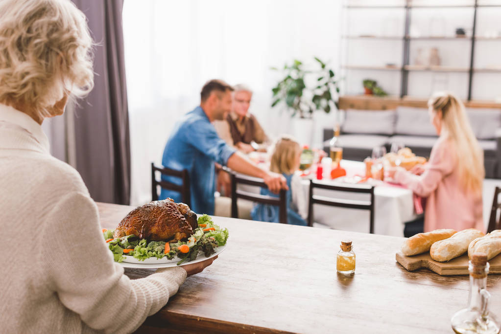 enfoque selectivo de la abuela sosteniendo plato con sabroso pavo en el día de Acción de Gracias
   - Foto, Imagen