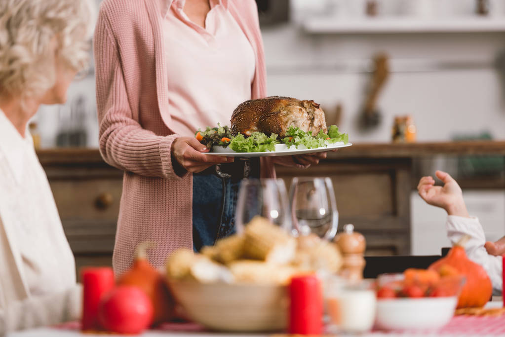 καλλιεργημένη άποψη της μητέρας κρατώντας πιάτο με γαλοπούλα την ημέρα των Ευχαριστιών    - Φωτογραφία, εικόνα