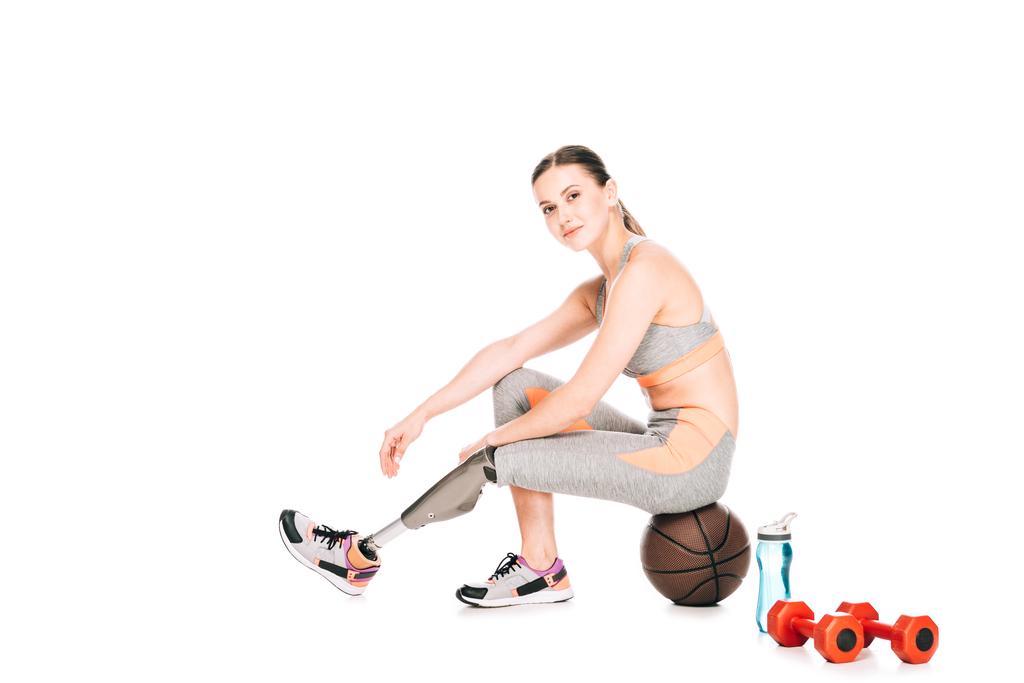 mosolygó fogyatékkal élő sportnő protézissel ül kosárlabda fehér - Fotó, kép