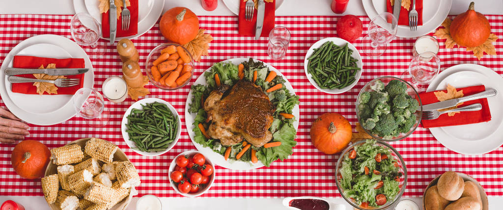 plan panoramique de la table avec salade, verres, bougies, légumes, moulin à poivre, maïs, moulin à sel et citrouilles le jour de Thanksgiving
  - Photo, image