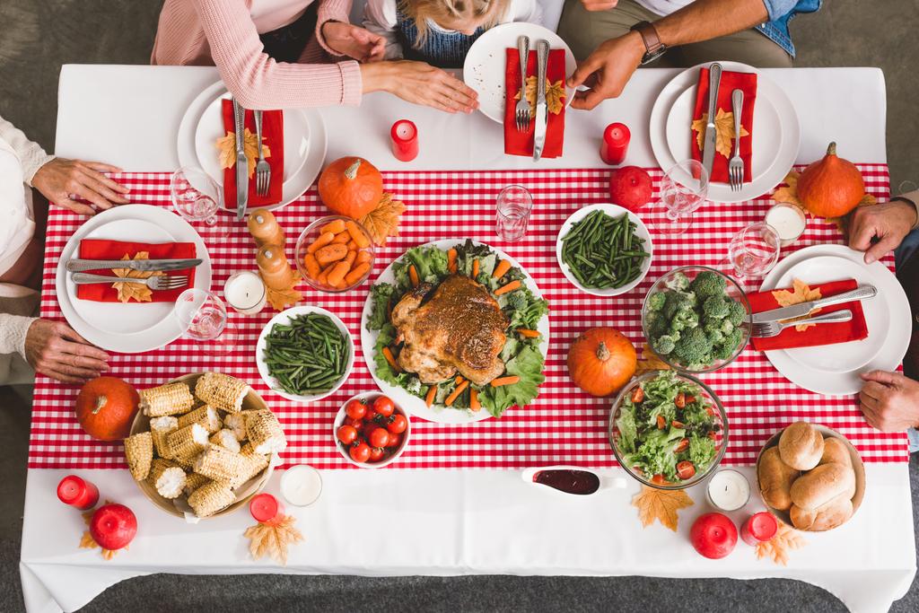 Вид сверху на членов семьи, сидящих за столом в День Благодарения
      - Фото, изображение