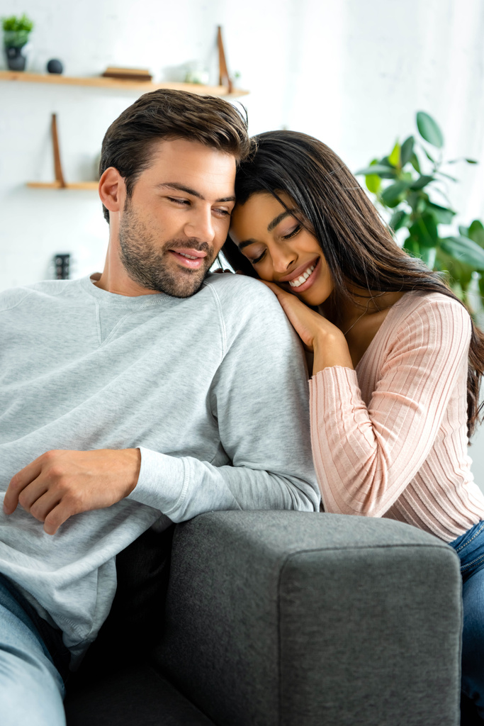 africano americano mujer y guapo hombre sonriendo y abrazando en apartamento
  - Foto, imagen