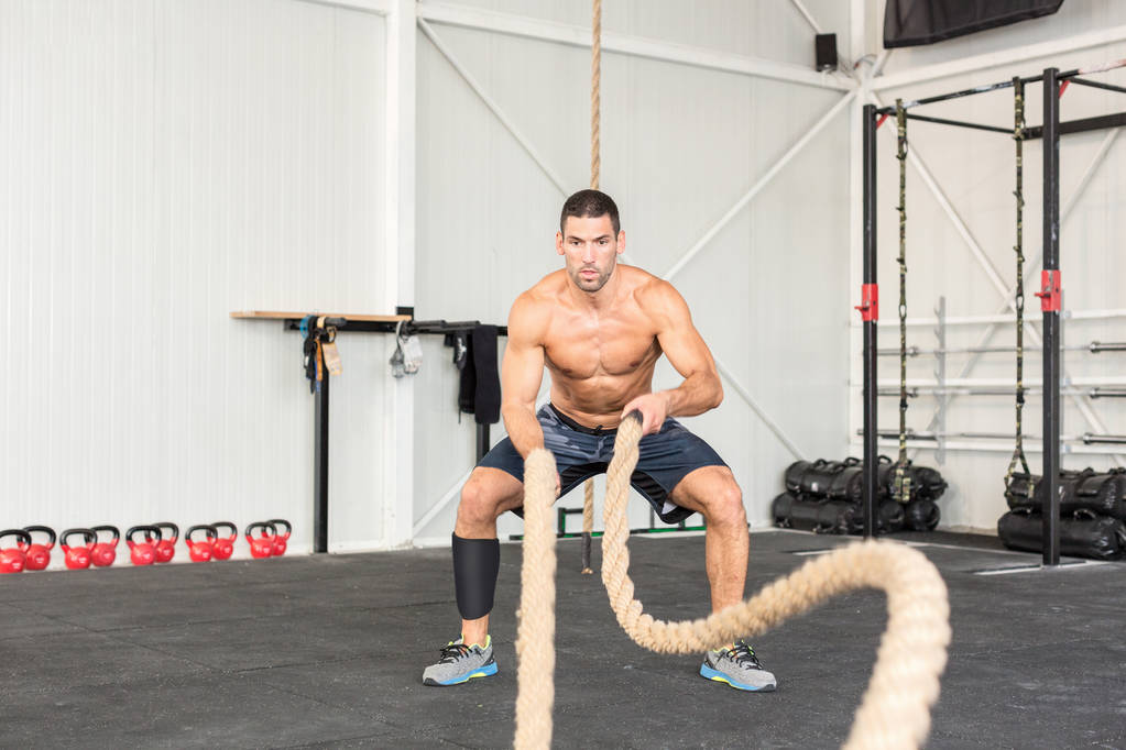 Uomini con corde da battaglia si allenano in palestra. CrossFit conc
 - Foto, immagini