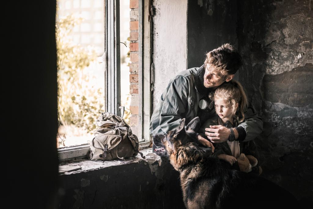 homem abraçando criança perto de cão pastor alemão no edifício abandonado, conceito pós-apocalíptico
 - Foto, Imagem