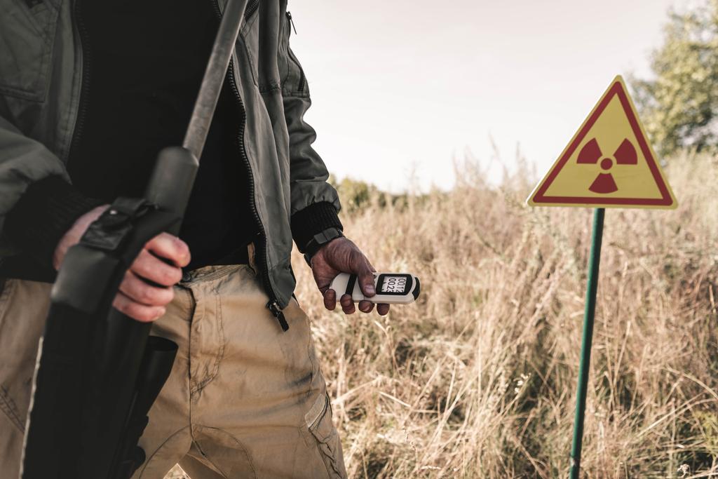 vue recadrée de l'homme tenant radiomètre et pistolet près symbole toxique, concept post-apocalyptique
 - Photo, image