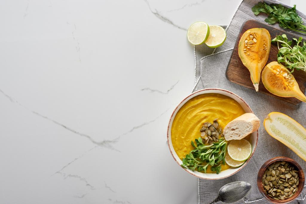 top view of autumnal mashed pumpkin soup on wooden cutting board on marble surface - Photo, Image