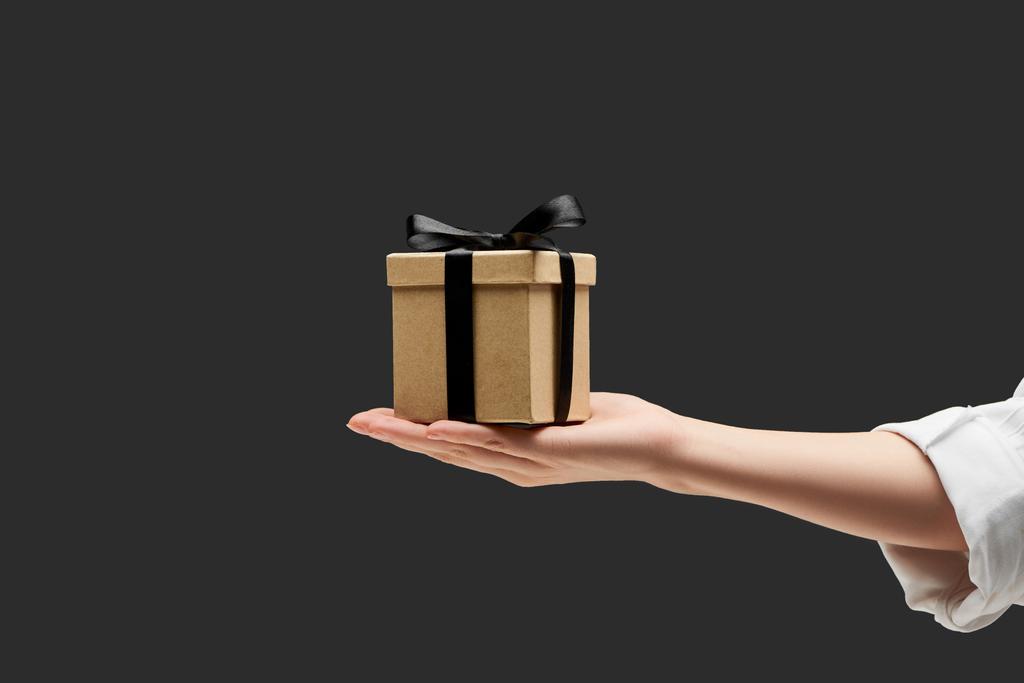 обрезанный вид женщины с подарочной коробкой в руке изолированы на черный
 - Фото, изображение