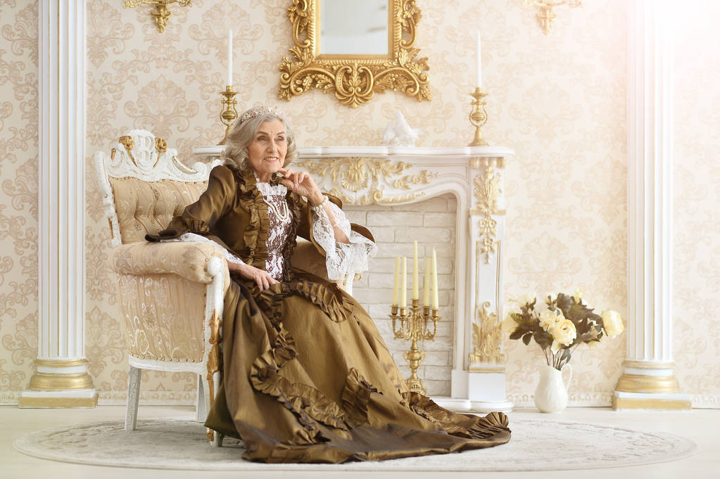 bela mulher sênior rainha sentado em poltrona
 - Foto, Imagem