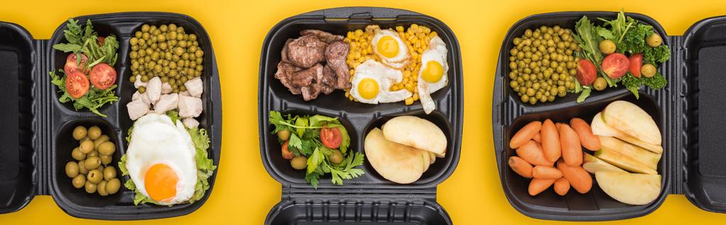 панорамний знімок екологічних пакетів з овочами, яблуками, м'ясом, смаженими яйцями та салатами ізольовані на жовтому
     - Фото, зображення