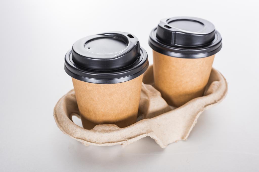 Pappbecher mit Kaffee in Papptablett auf weißem Hintergrund  - Foto, Bild