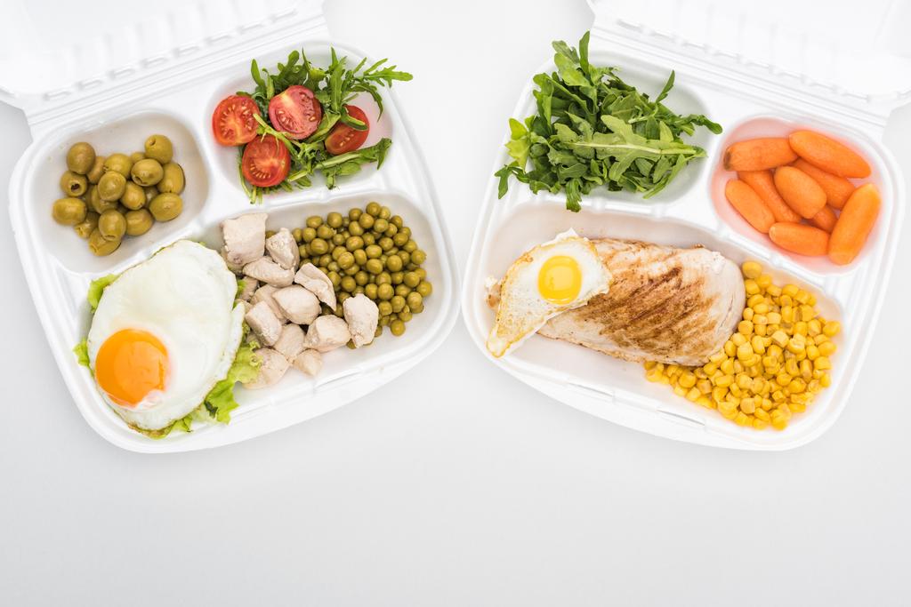 top view ökológiai csomagok arugula, zöldségek, hús, tükörtojás és saláta fehér alapon  - Fotó, kép