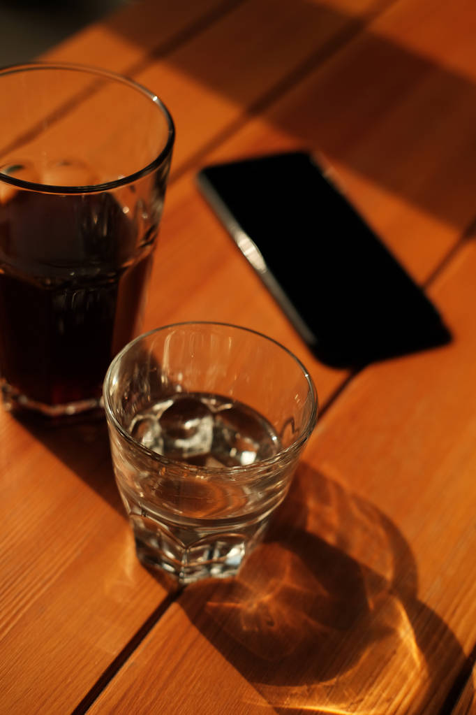 Gläser mit frisch gebrühtem schwarzen Kaffee und klarem Wasser auf dem Kaffeetisch - Foto, Bild