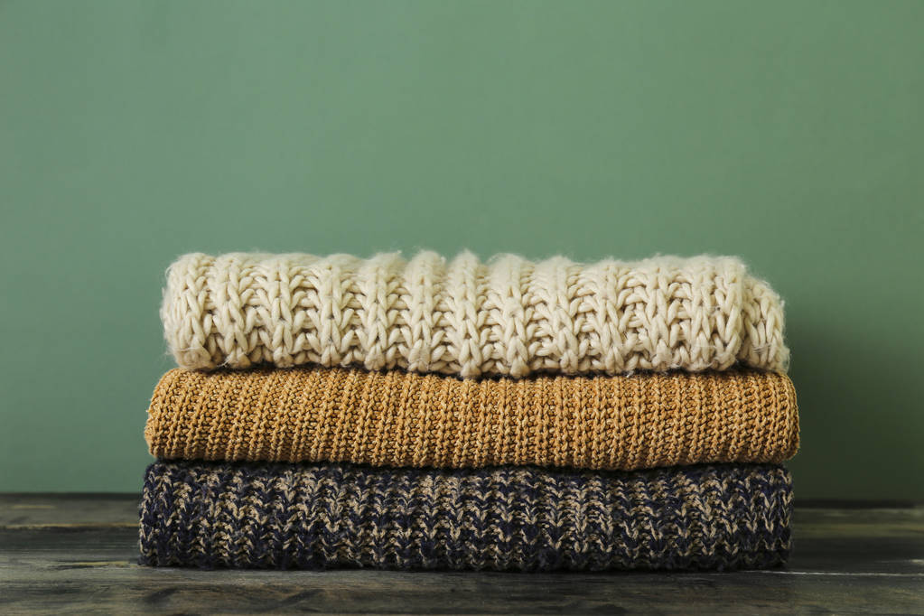 Pile de pulls tricotés de différentes couleurs et motifs parfaitement empilés
. - Photo, image
