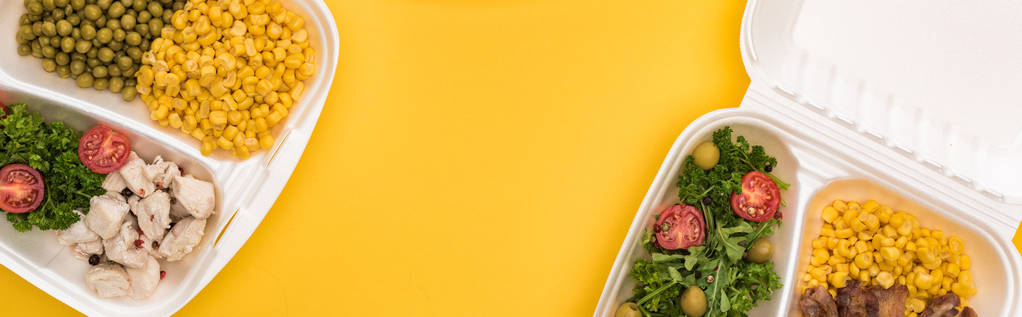 panoramiczne ujęcie opakowań ekologicznych z warzywami, mięsem, jajami smażonymi i sałatkami izolowanymi na żółto     - Zdjęcie, obraz