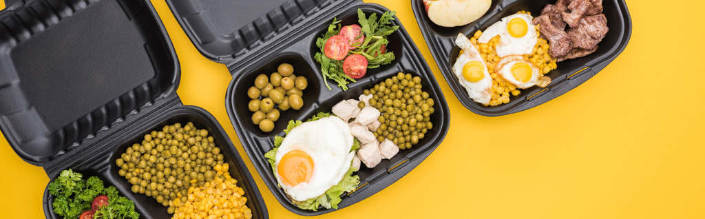 πανοραμική λήψη των οικολογικών πακέτων με λαχανικά, κρέας, τηγανητά αυγά και σαλάτες που απομονώνονται σε κίτρινο     - Φωτογραφία, εικόνα