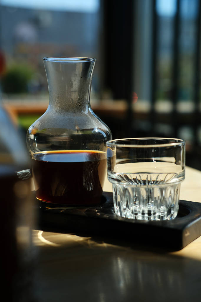 kancsó és üveg friss hideg főzött fekete kávét kávézó asztal - Fotó, kép