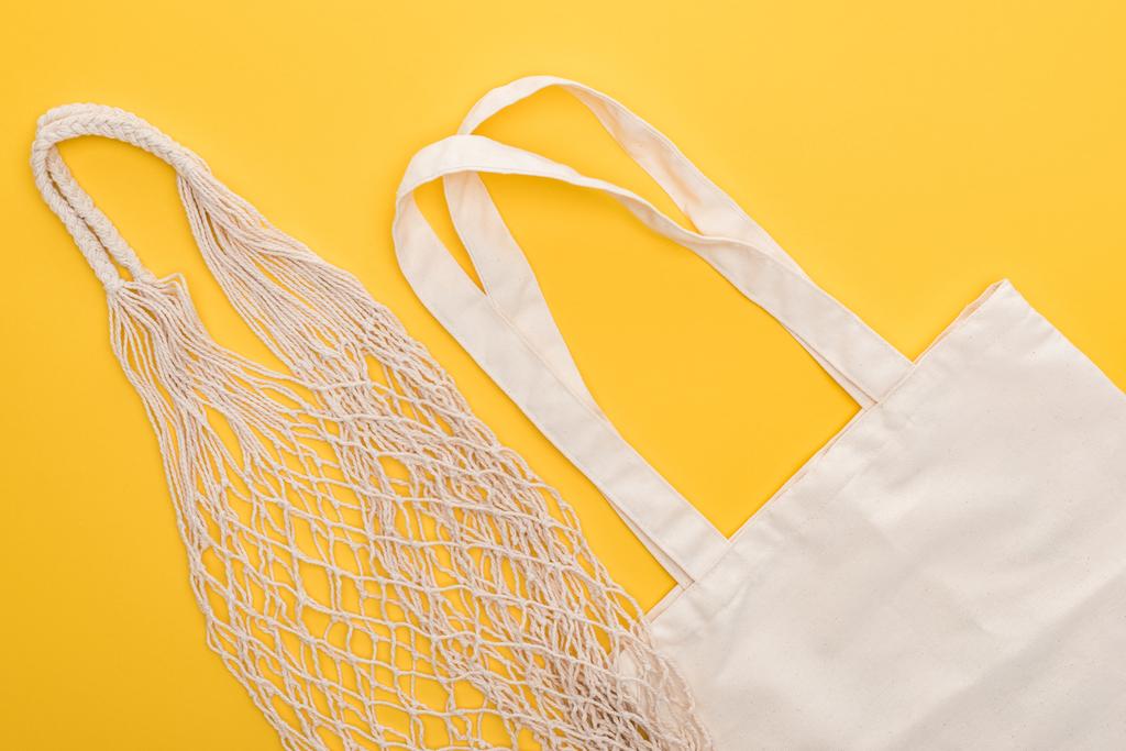 vue du dessus des sacs en coton blanc et des sacs à ficelle isolés sur jaune
 - Photo, image