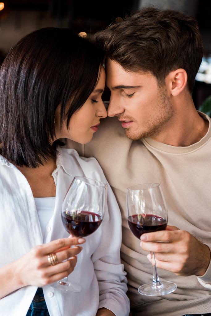 目を閉じた男と女は赤ワインで眼鏡をかけ  - 写真・画像